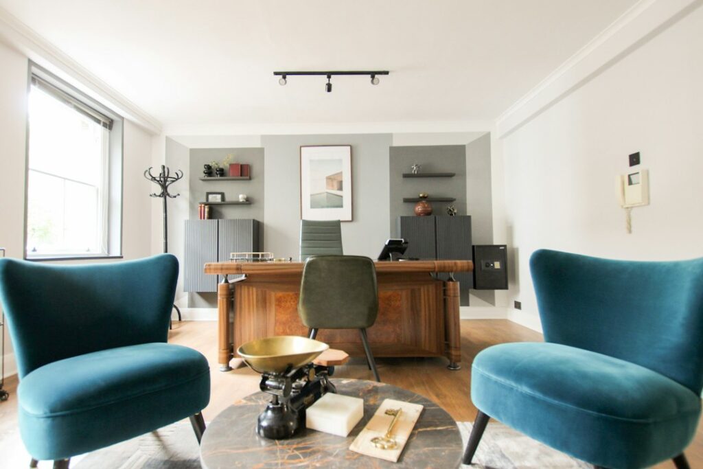 Bright office with two blue chairs and a wooden desk