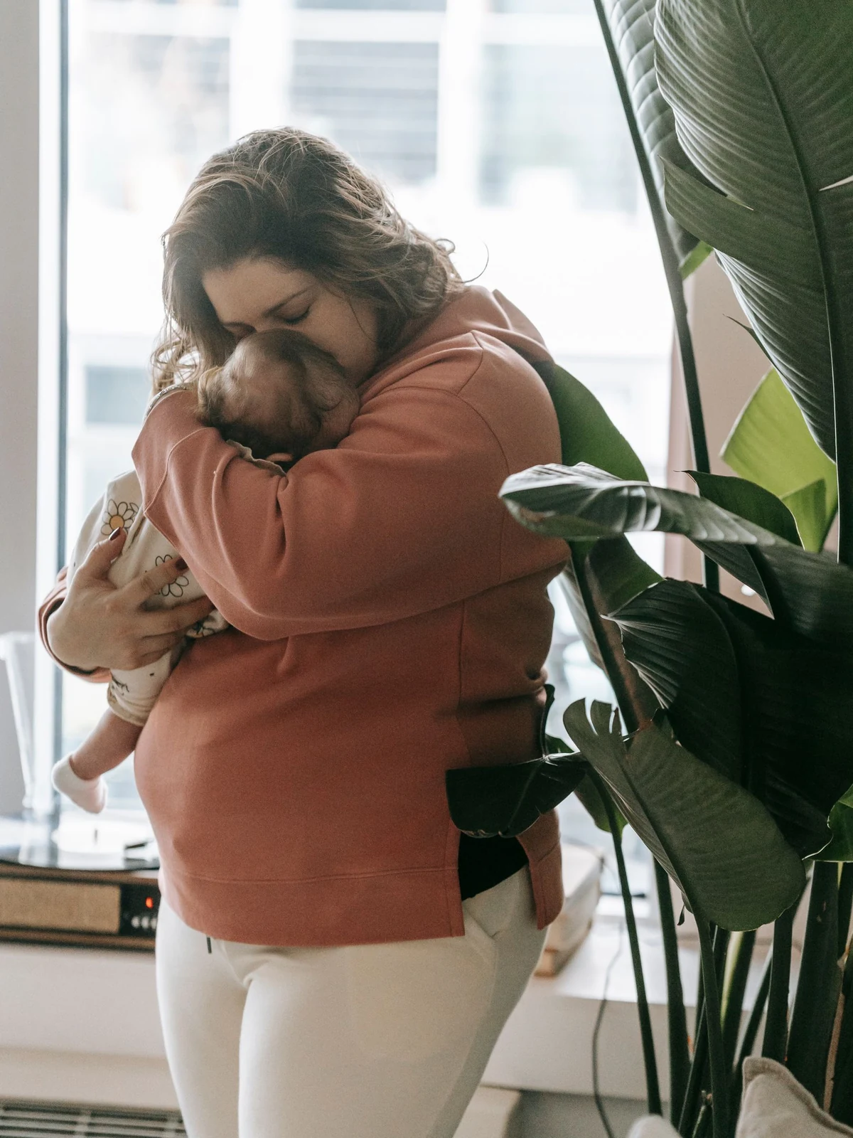 A parent holding their newborn baby close