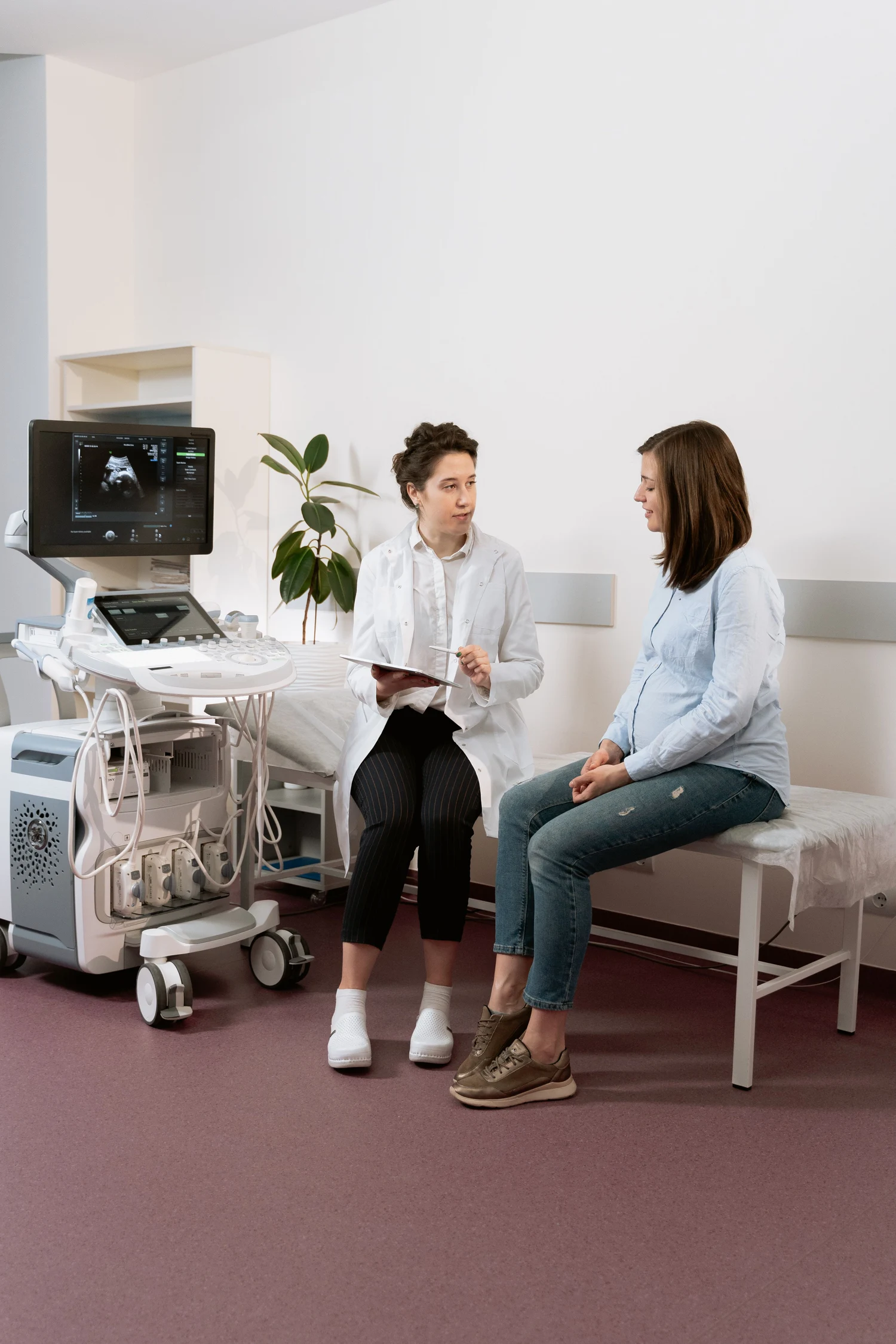 A woman discussing her care with a clinician in a consultation room