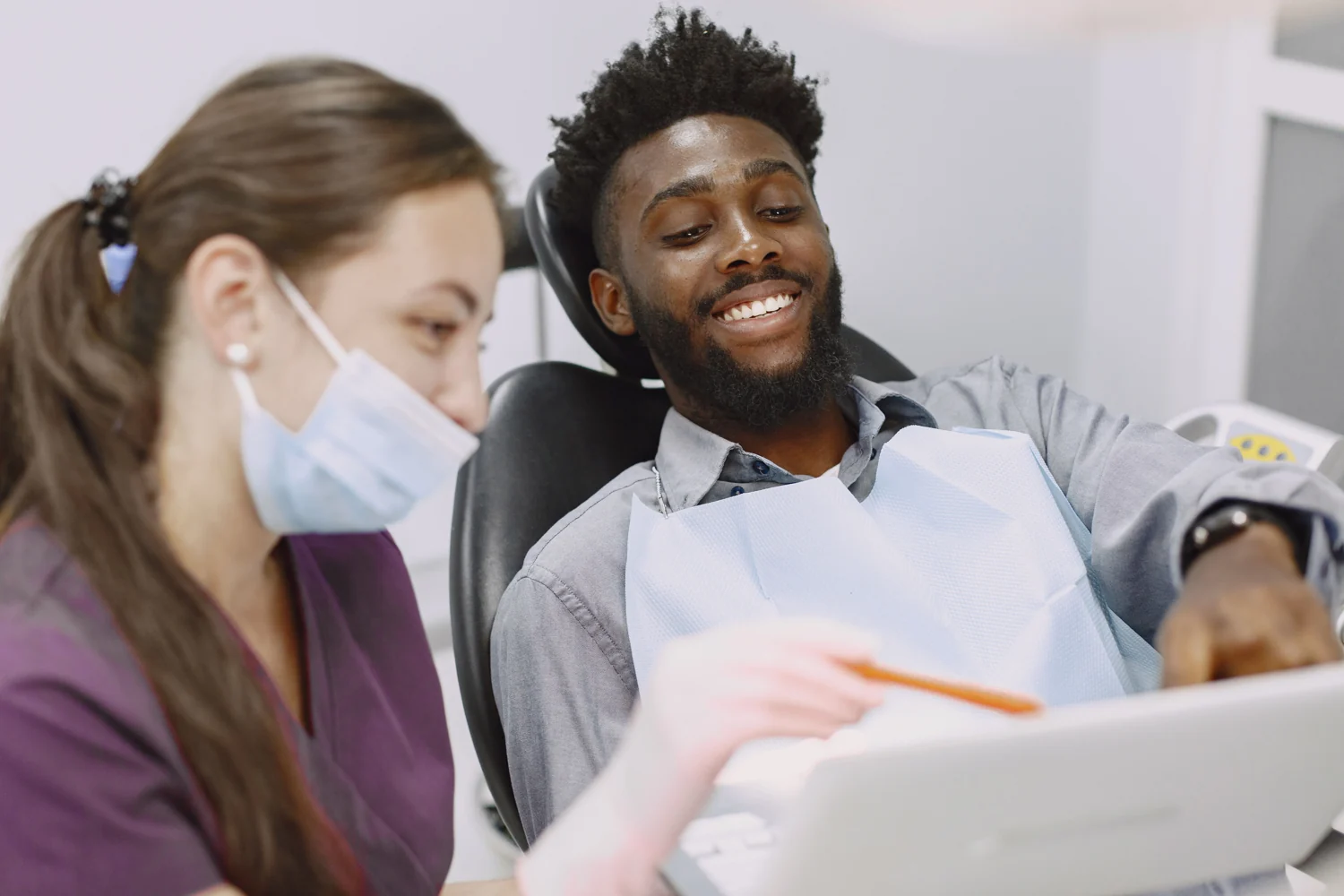 Dentist explaining a dental examination to a patient in a bright modern clinic