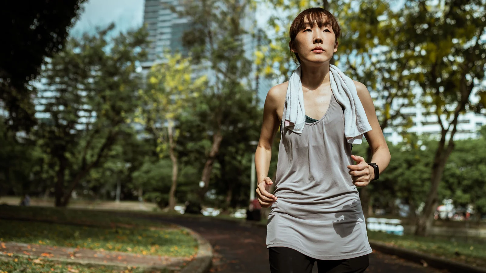 A woman running through a sunlit park