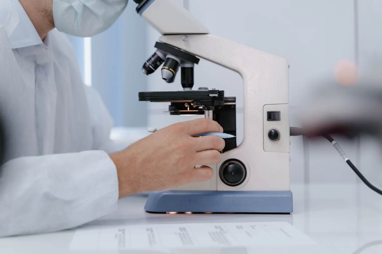 A laboratory professional working with a microscope
